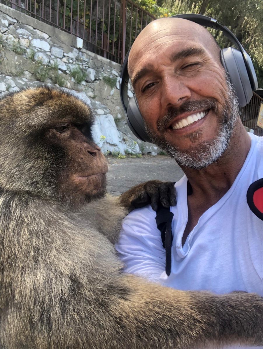 Jason “Monkey Man” Cruz smiling beside a Barbary macaque on the Rock of Gibraltar